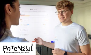 Zwei Personen im Gespräch vor einem Bildschirm mit einer Roadmap, eine Person trägt ein weißes T-Shirt und Brille