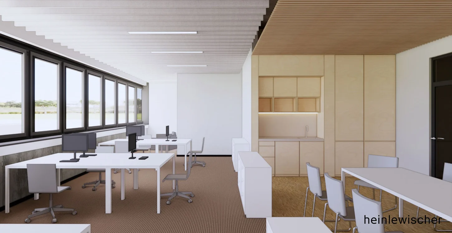 Helles Büro mit mehreren Schreibtischen, Bürostühlen, großen Fenstern links und einer Wand mit Einbauschränken rechts